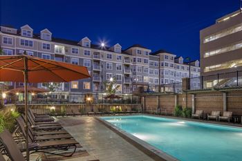the swimming pool at night at Reveal Hackensack apartments